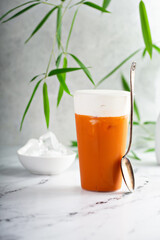 Iced orange mango tea with cold foam in tall glass