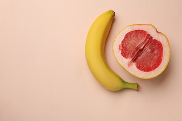 Banana and half of grapefruit on beige background, flat lay with space for text. Sex concept