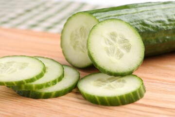 Cut ripe cucumber on wooden board, closeup