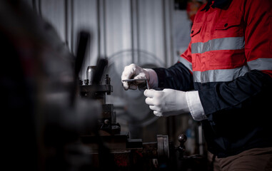 Industry engineer wearing safety uniform used vernier caliper to measure the object control operating machine working in industry factory is metal manufacturing machine industry concept.