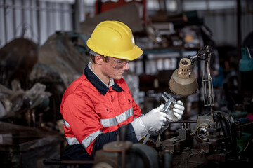 Industry engineer wearing safety uniform used vernier caliper to measure the object control...