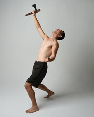 Full length portrait of fit handsome shirtless asian male model,  Holding viking axe weapon,...