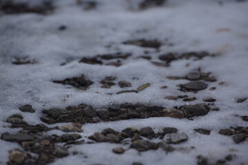 Pebbles on snow, grey lighting, macro