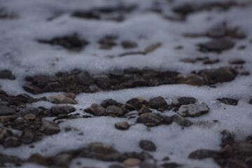 Pebbles on snow, grey lighting, macro