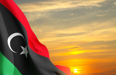 Flag of Libya against the sunset. Background for National Holidays - obrazy, fototapety, plakaty