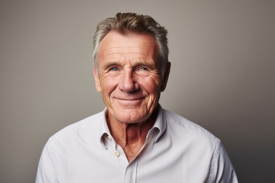 Portrait of a smiling senior man. Isolated on grey background.