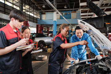 Male professional automotive supervisor advises and inspects Black female mechanic worker about...