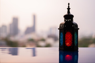 Lantern with dusk sky and blurred city background for the Muslim feast of the holy month of Ramadan Kareem.