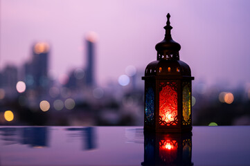 Lantern with dusk sky and city bokeh light background for the Muslim feast of the holy month of Ramadan Kareem.