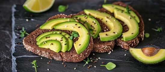 Vegetarian food with sliced avocado on toast made from whole wheat bread.