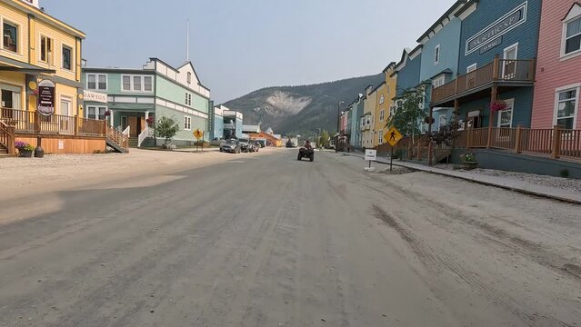 Drive on an unpaved road through the historic gold mining town of Dawson City, wooden buildings, hotels, Yukon, Canada, North America