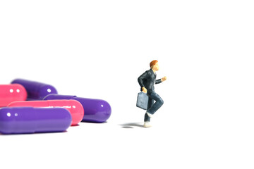 Miniature people toy figure photography. A boy pupil student running in front of medical drug pill....