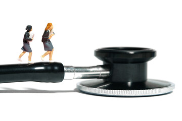 Miniature people toy figure photography. Two girl pupil students running above stethoscope....