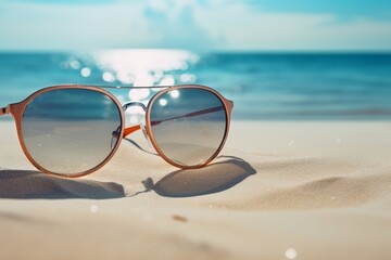 Fototapeta na wymiar A pair of sunglasses resting on the sun-soaked sandy beach.