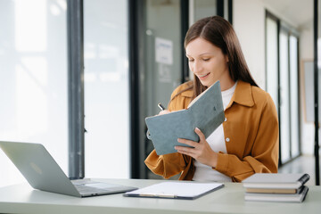 Businesswoman working in the office with working notepad, tablet and laptop documents .