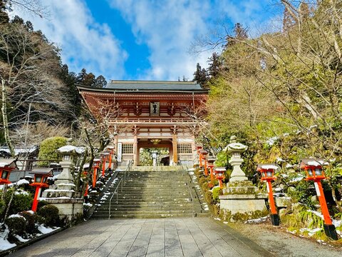 The beginning of a hiking trail in the snowy forest to the Kuramadera Temple at Kyoto, Japan on a winter day 