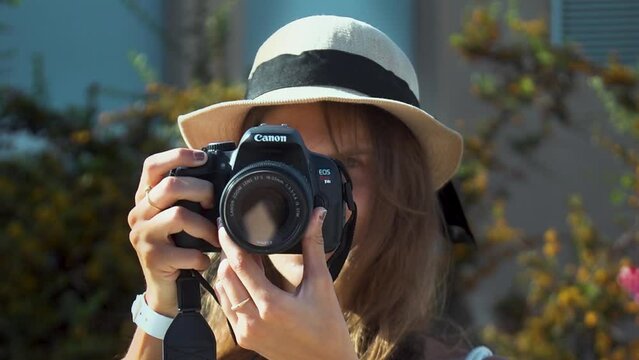 Portrait Girl with a Summer Straw Hat holding Camera to take Photos in a Sunny Day, Slow Motion