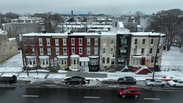 Row houses with colorful facades on a snowy street. Urban USA city housing during winter day with snow.