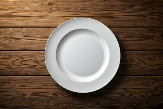 A white empty plate is served on wooden background from top view