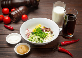 Okroshka with kvass or kefir. On a wooden background.