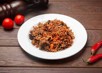 Pilaf with lamb. On a wooden background.