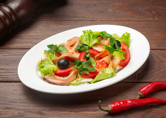 Vegetable salad with salmon. On a wooden background.