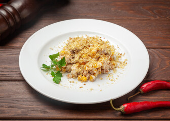 Chicken and corn salad. On a wooden background.