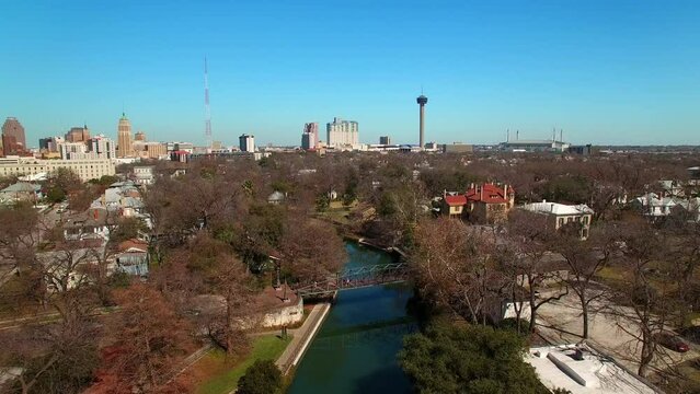 Aerial Forward Shot Of Johnson Street Pedestrian Bridge Over River Canal In Residential City Against Clear Sky - San Antonio, Texas