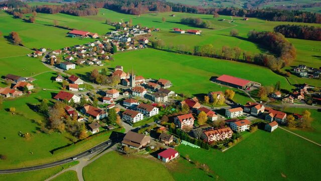 Houses And Green Fields In The Village of Mezieres In Fribourg, Switzerland. - helicopter aerial shot