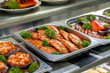 Metal trays with fresh food in a canteen