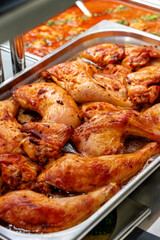 Metal tray with fresh baked chicken in a canteen