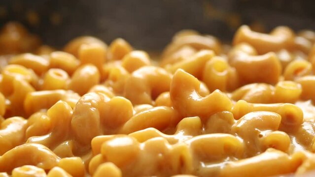 Boiled Macaroni and Cheese Sauce Cooking in a Pan. Close-up shot