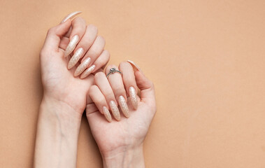 Hand on a brown background and beautiful pearl manicure close up. Ссылка ×Название:.Hands on a brown background and beautiful pearl manicure