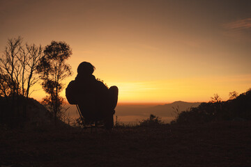 landscape and travel concept with solo freelancer man sit on chair and see sunrise with layer of...
