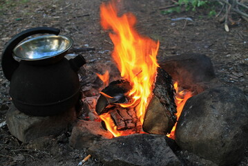 Camping kettle and fire surrounded by stones. Republic of Karelia, Russia.