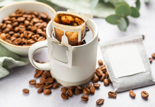 Drip coffee bag with ground coffee in  cup