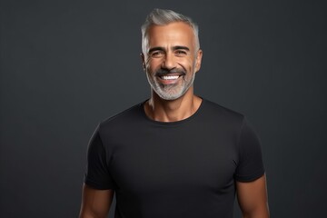 Portrait of handsome mature man in black t-shirt on grey background