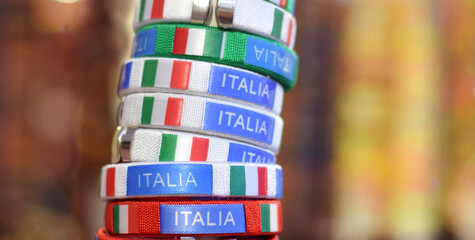 A stack of bracelets or armlets in Italian colors of flag green, red, white in souvenir shop in...