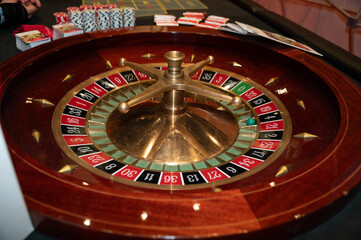 Roulette wheel closeup with chips in the background