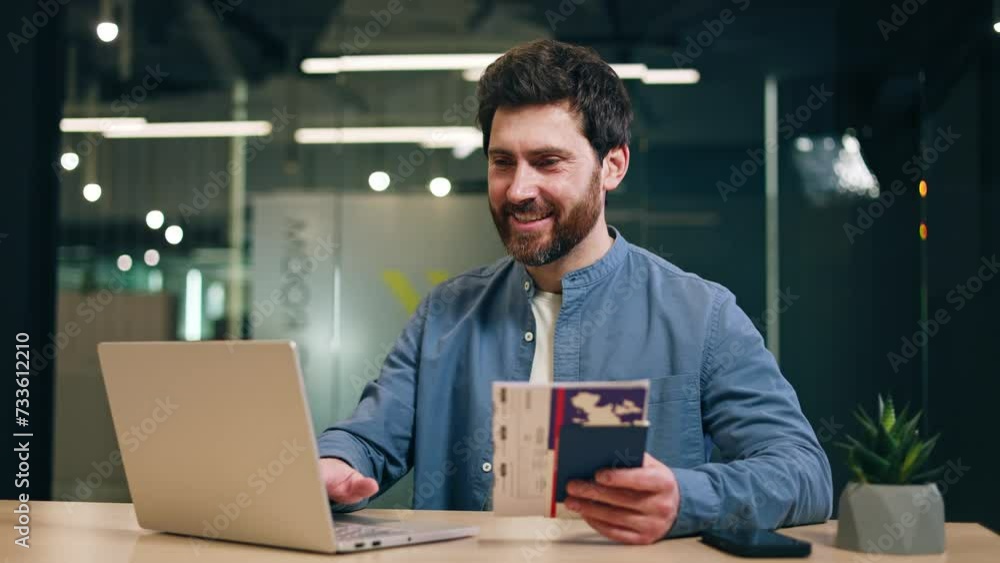 Wall mural Satisfied entrepreneur using computer while resting hand with cruise admission ticket in passport on desktop with succulent. Happy man checking living conditions in cabin on ship on company website.