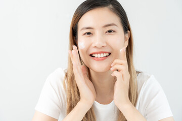 Beautiful Asian woman smile use cream for good skin. face of a healthy woman apply cream and...