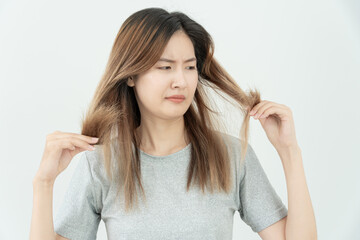 Asian woman very sad and upset looking at damaged hair, hair loss, hair thinning problem, vitamin...