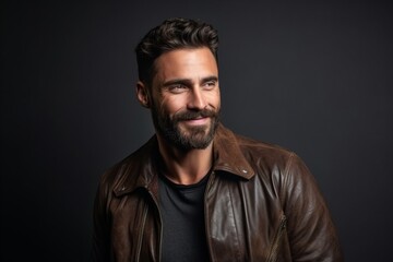 Portrait of a handsome man with beard and mustache wearing a leather jacket.