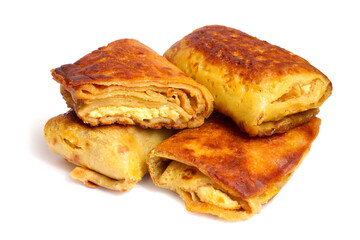 Homemade pancakes stuffed with cottage cheese. Lots of pancakes on a white background.