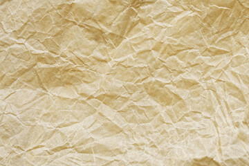 Crumpled light brown oiled paper used for food packaging and for baking in the kitchen. Background or backdrop. Photo