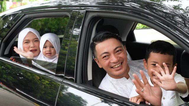 Asian muslim family sitting in the car looking out windows