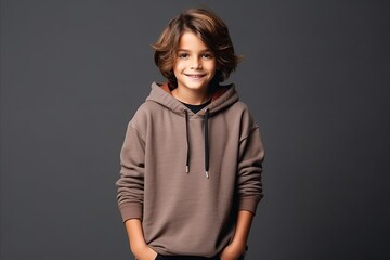 cute little boy in a hoodie on a dark gray background