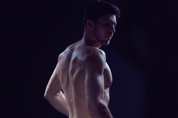 Fototapeta premium Closeup Image of Confident Thinking Caucasian Bodybuilder Athlete Man Posing With Naked Torso Against Dark