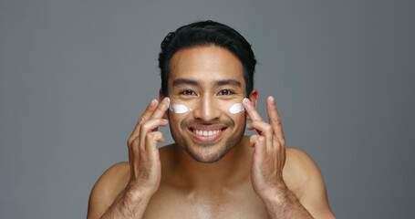 Face, cream and man with skincare, glow and dermatology with grooming, wellness and shine on grey...