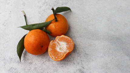 Fresh juicy tangerines on light grey table, closeup. Space for text. Orange fruit for healthy diet